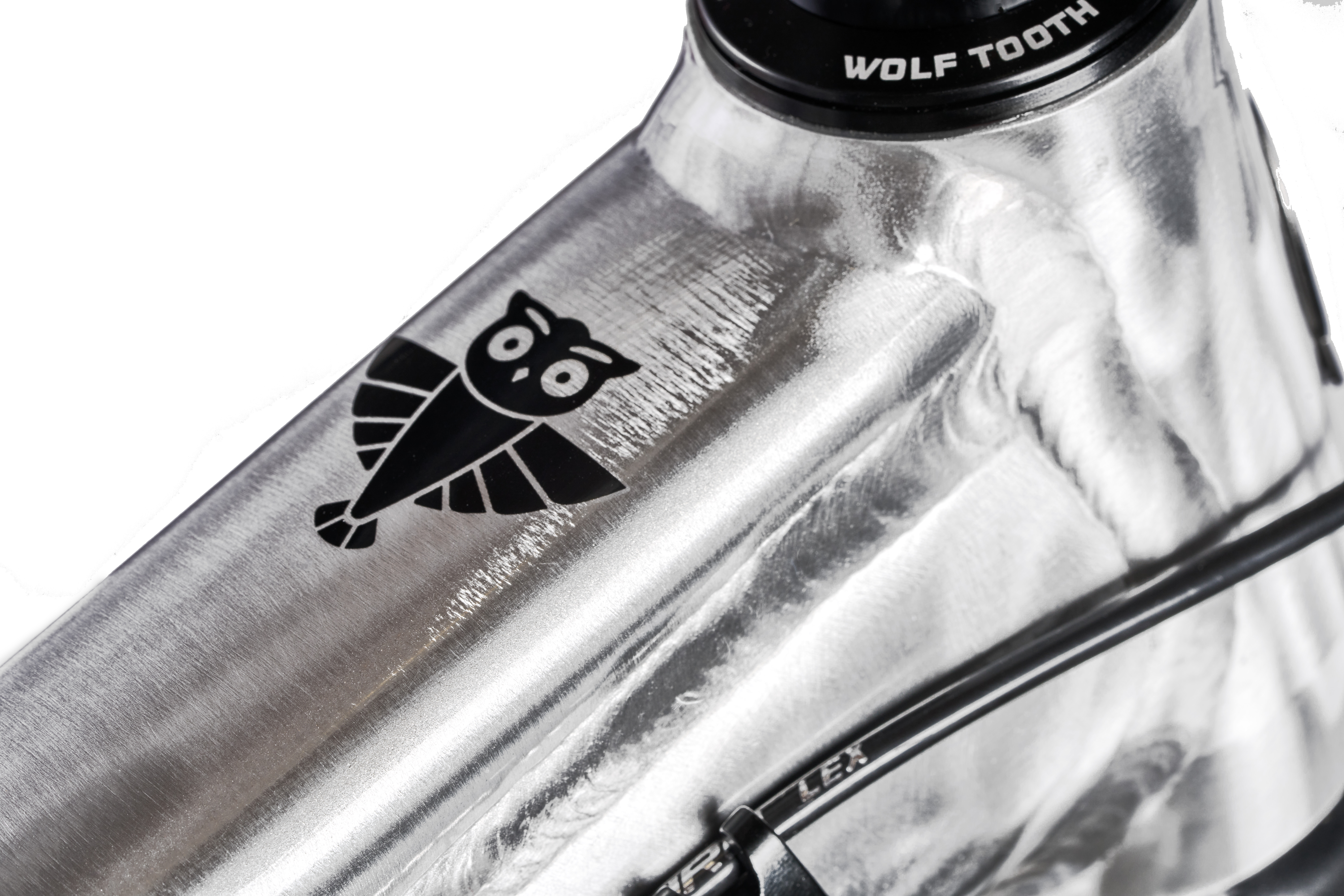 Close-up of a bicycle frame with an owl logo.