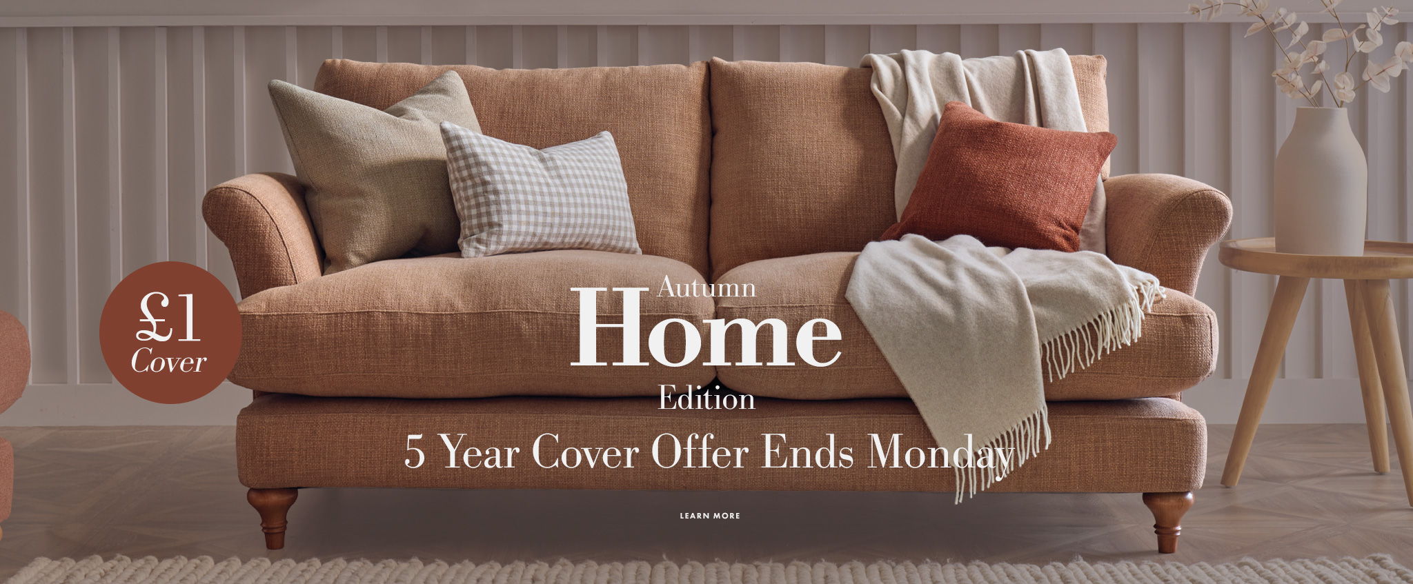 A cosy sofa with decorative pillows and a throw blanket.