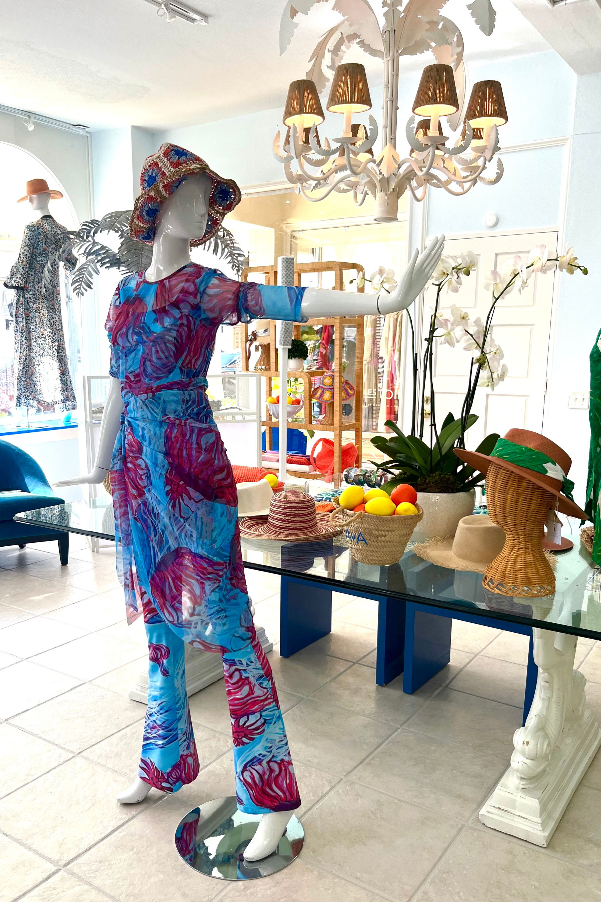 Mannequin in colorful outfit displaying in a boutique with various decorations.