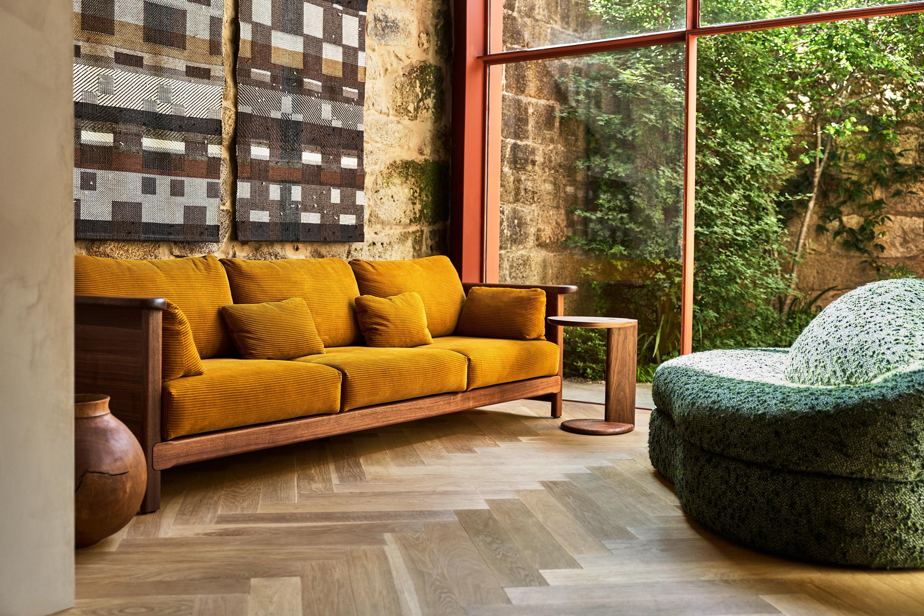 Cozy living room with a yellow couch and green chair by large windows.