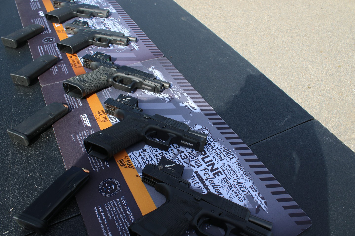 Various handguns displayed on a table with instructional material.