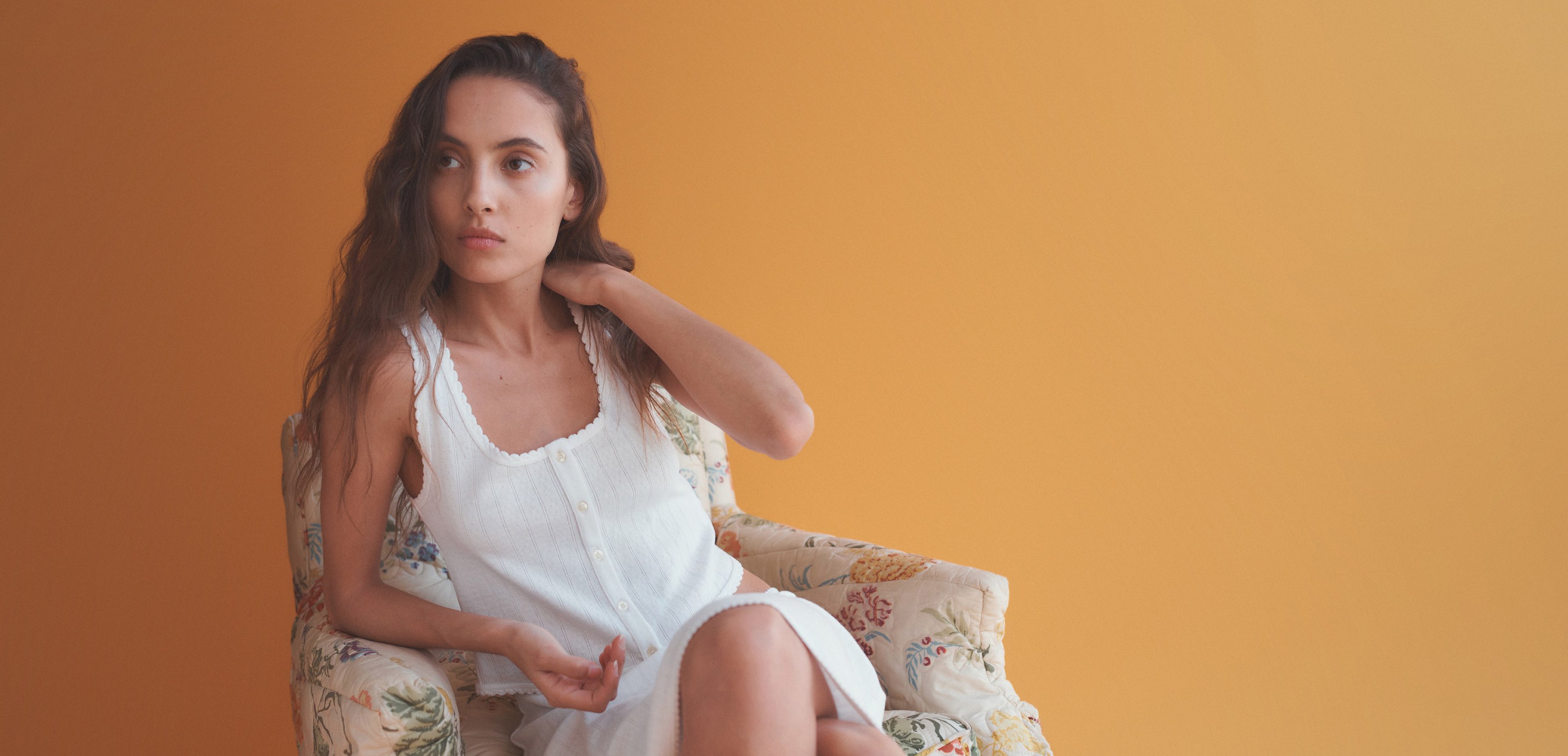 Woman in chair with hand on neck