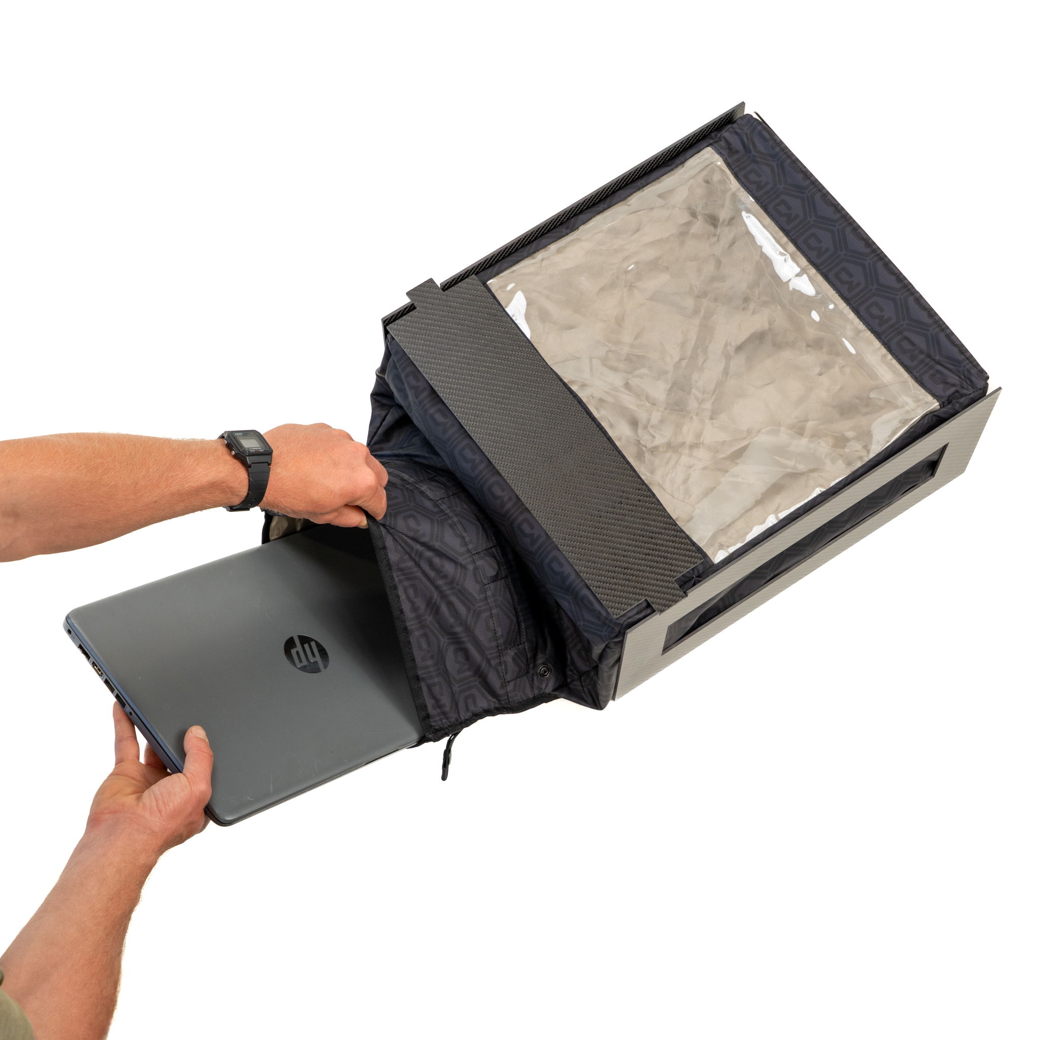 Person retrieving a black bag from a rectangular container.