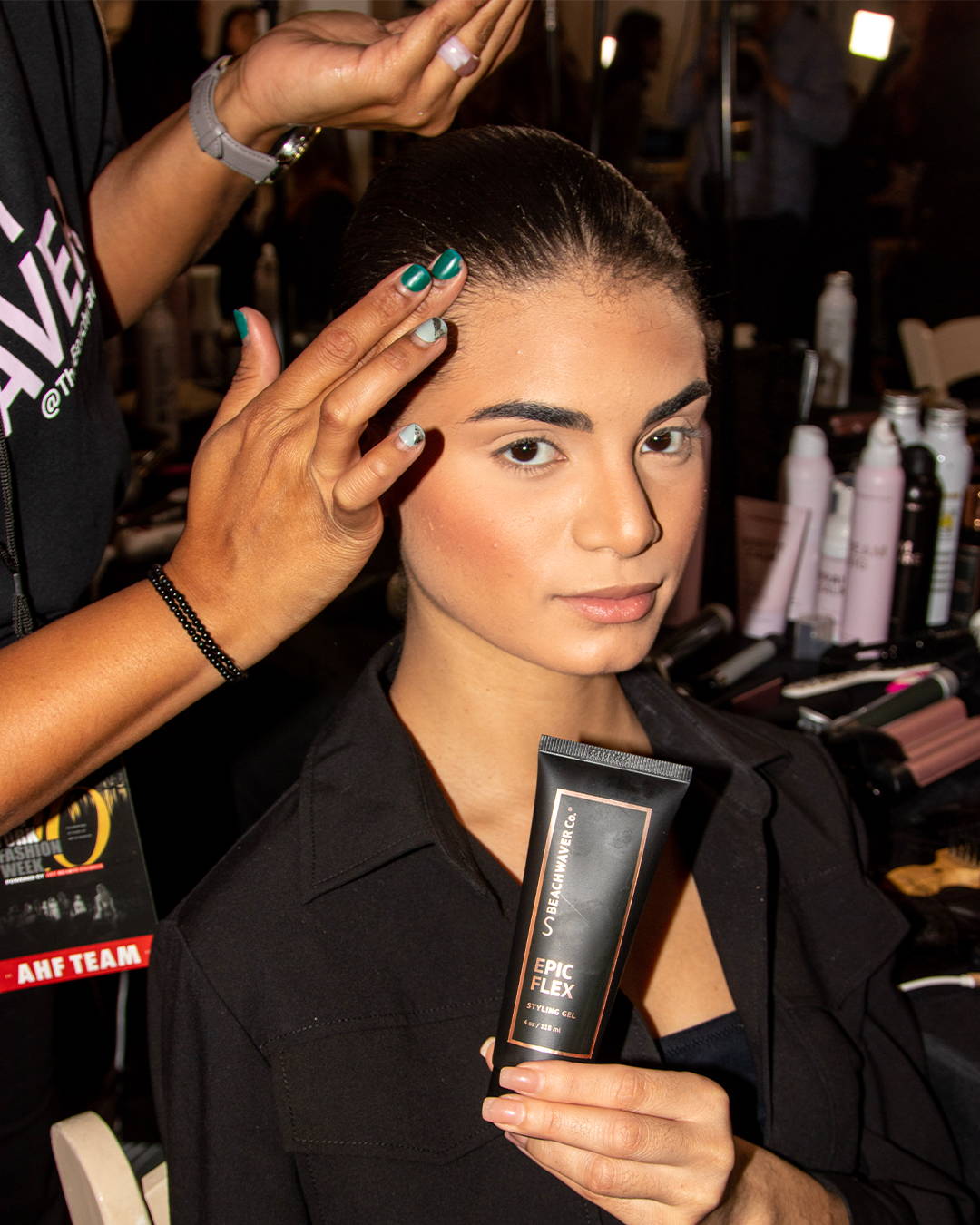 Image of a model at NYFW getting her hair slicked back with the Epic Flex Gel in a sleek look.