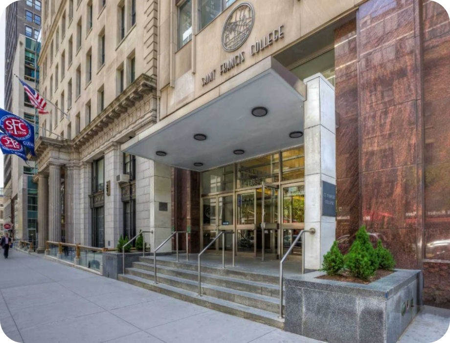 Entrance of a building with stairs, glass doors, and American flags.