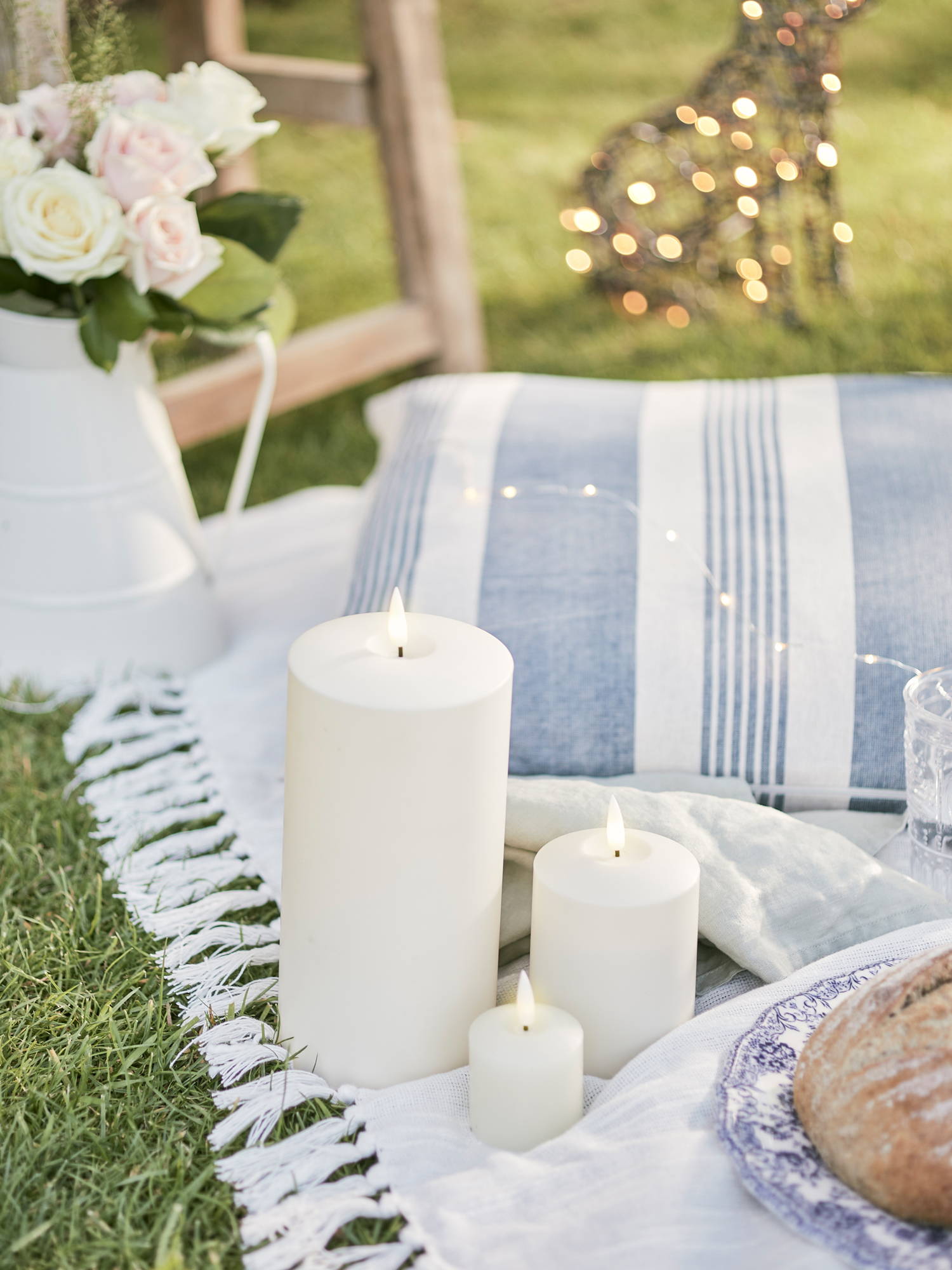 Outdoor candles and micro lights illuminated as part of picnic setting 