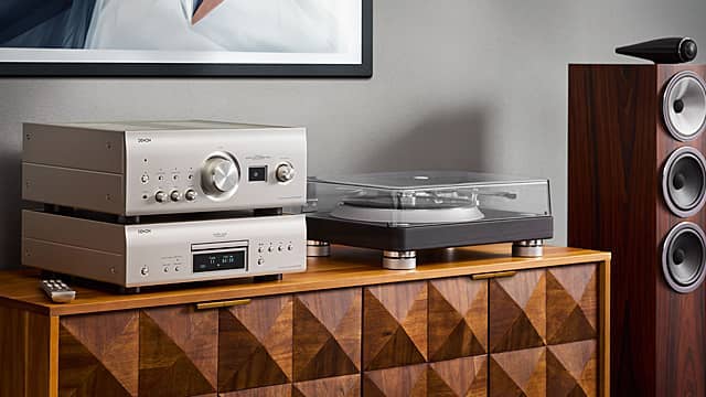 Modern audio equipment on a wooden cabinet with geometric patterns.