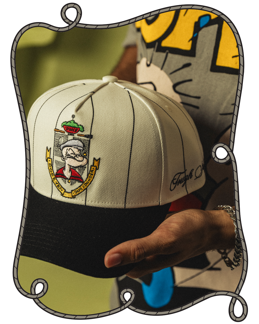 A person holding a white and black cap with a logo.