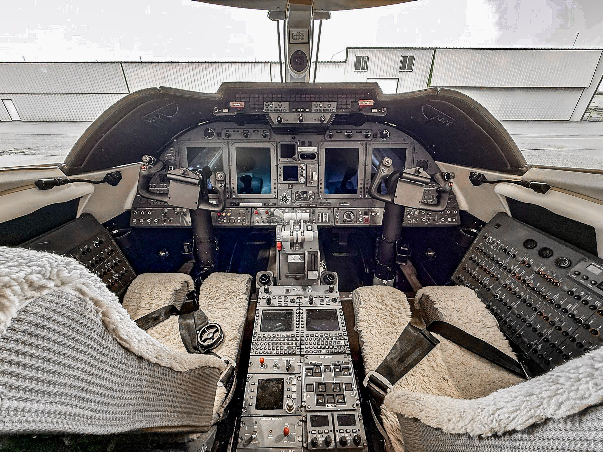 Cockpit interior with control panels and pilot seats.