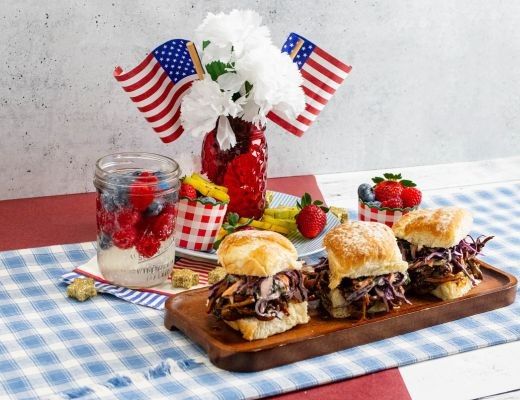 Assorted sliders with flowers and American flags on a picnic table.