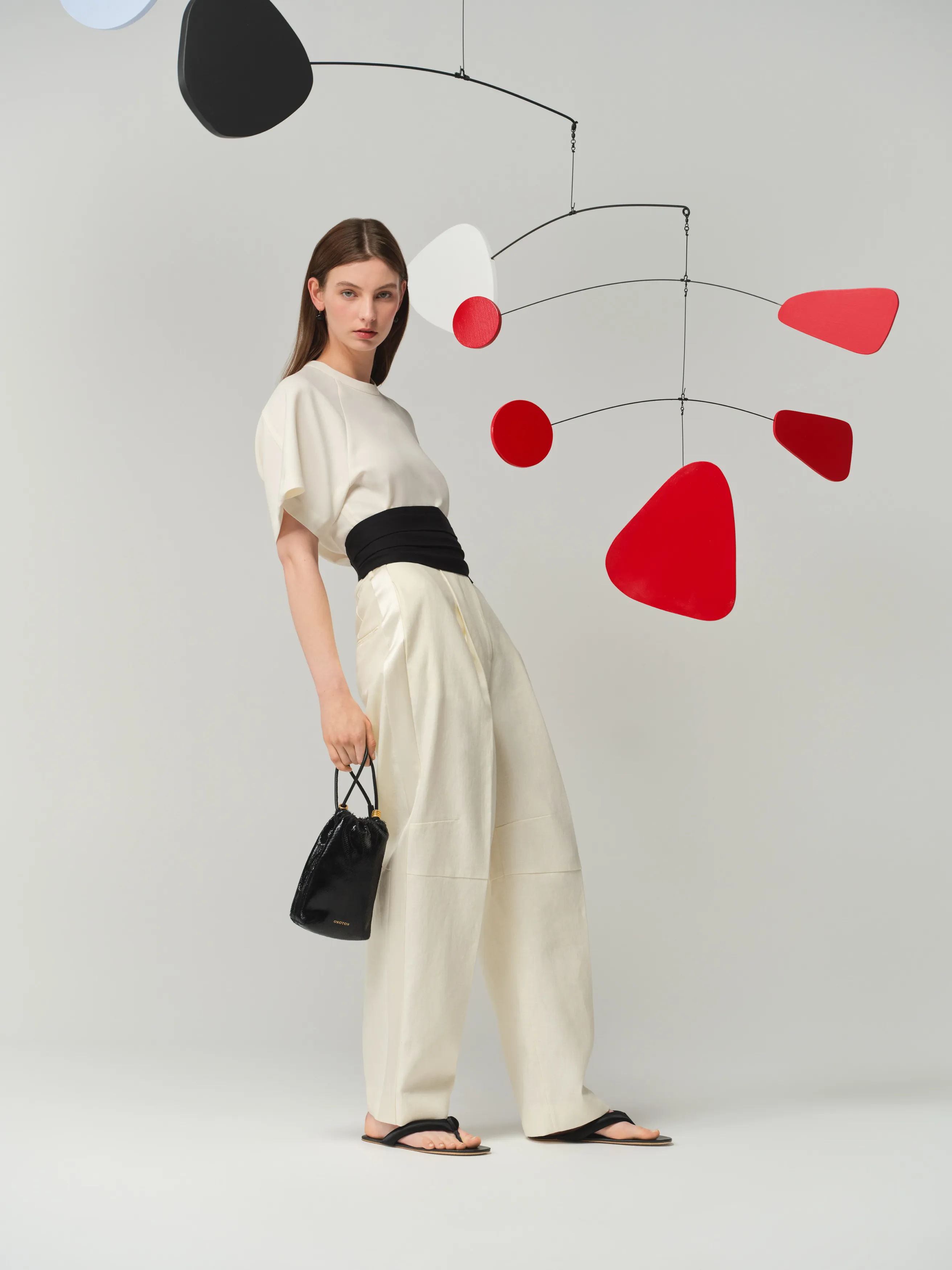 Model in stylish outfit with abstract mobile art background.