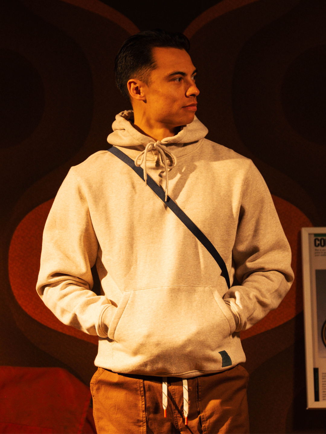 Person wearing a hoodie and standing with hands in pockets.