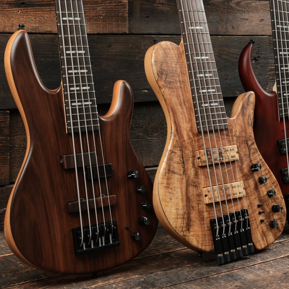 Two natrual wooden finish Sire bass guitars