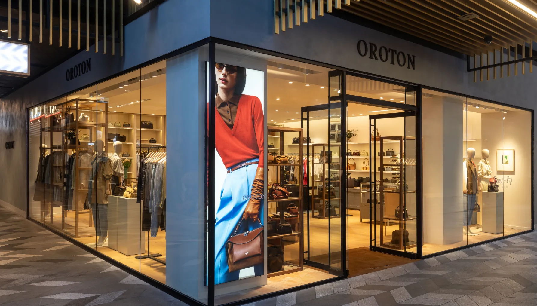 Clothing store display with a model in a red top and blue skirt.