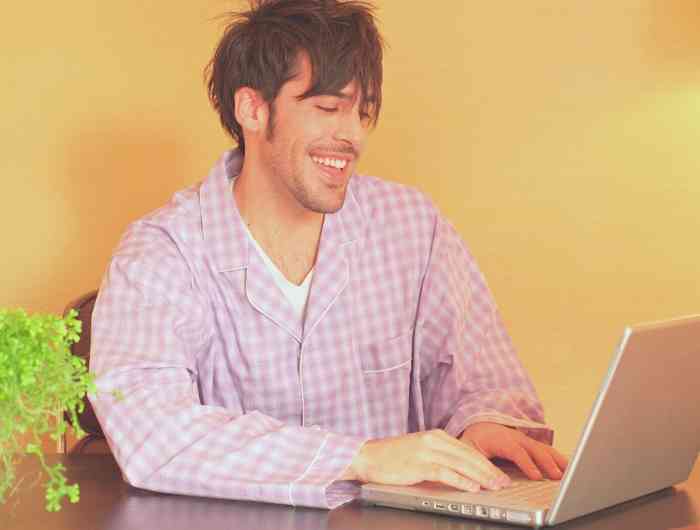 Man wearing pajamas working on computer