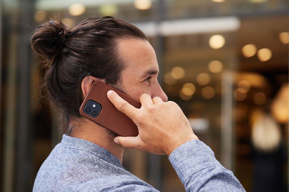 Mann hält Handy in iPhone Hülle von Goodwilhelm ans Ohr