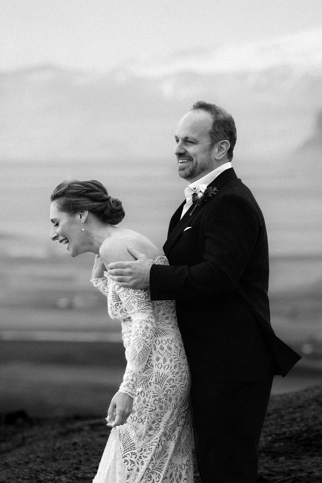 Happy couple laughing together in a scenic outdoor setting.
