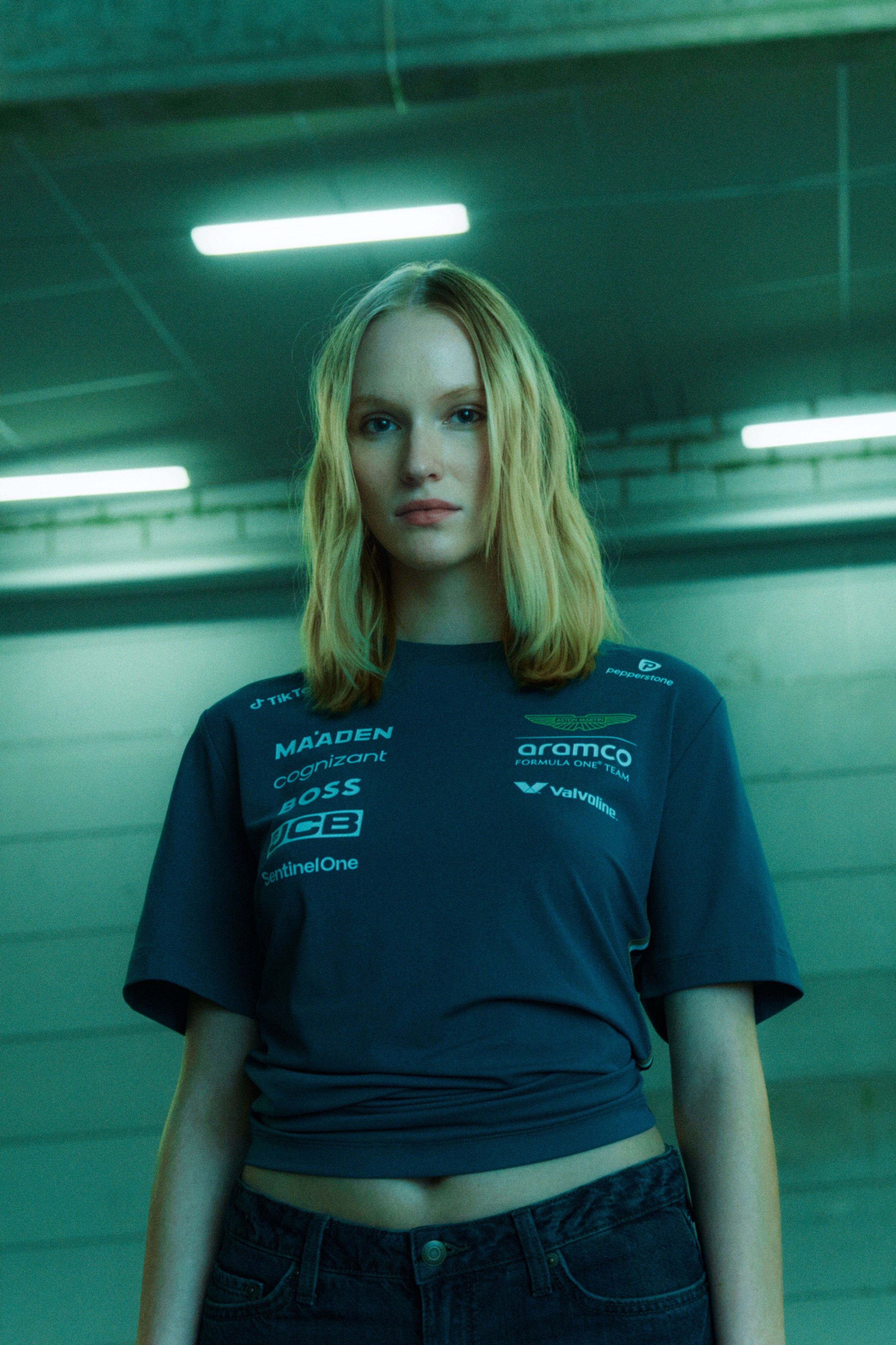 Young woman with shoulder-length blonde hair wearing a dark t-shirt and jeans.
