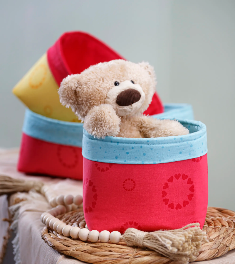 an adorable bear sits in a fabric storage bin - find the free sewing tutorial here!