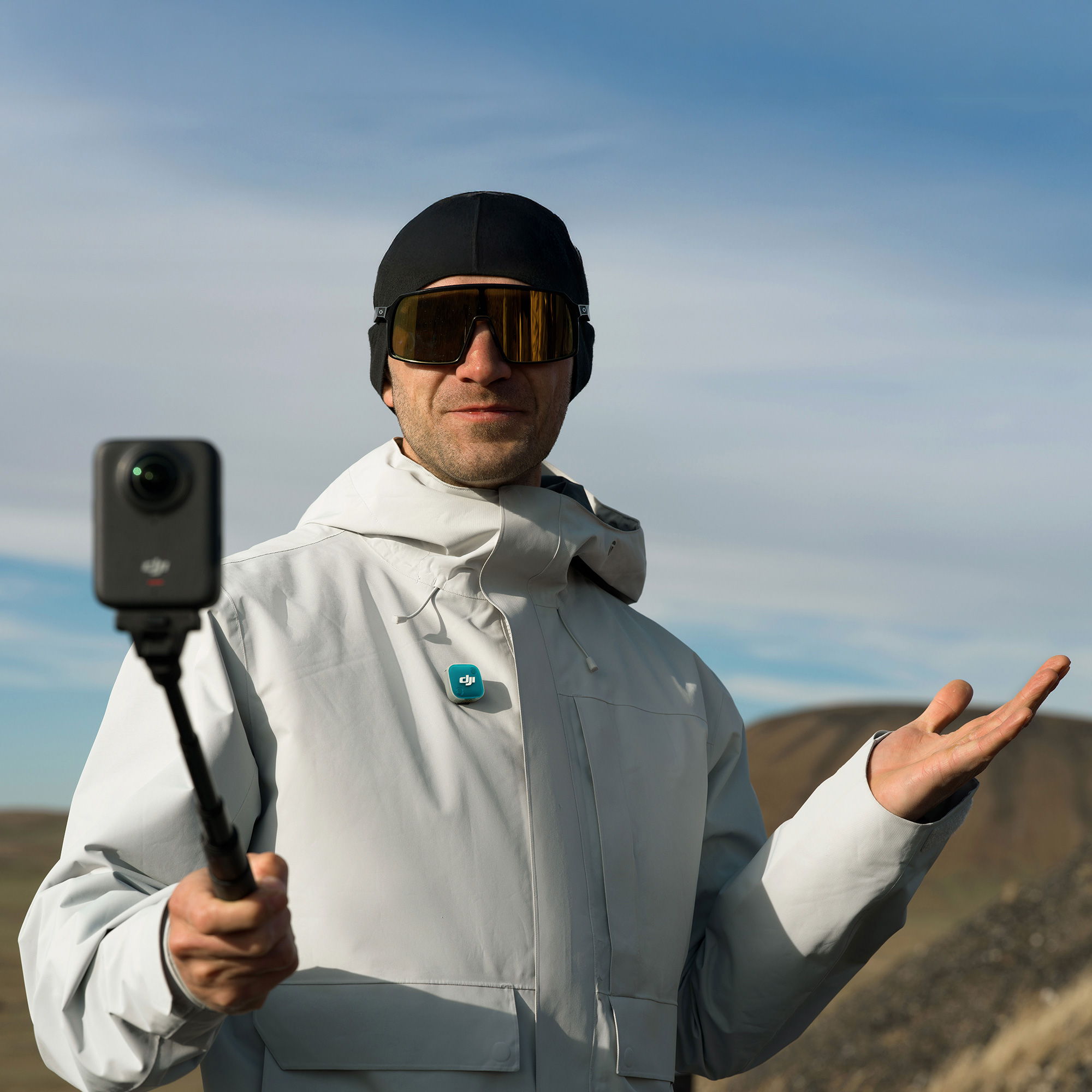 A person records video with an Osmo 360 and records audio with DJI Mic Mini 2 outdoors