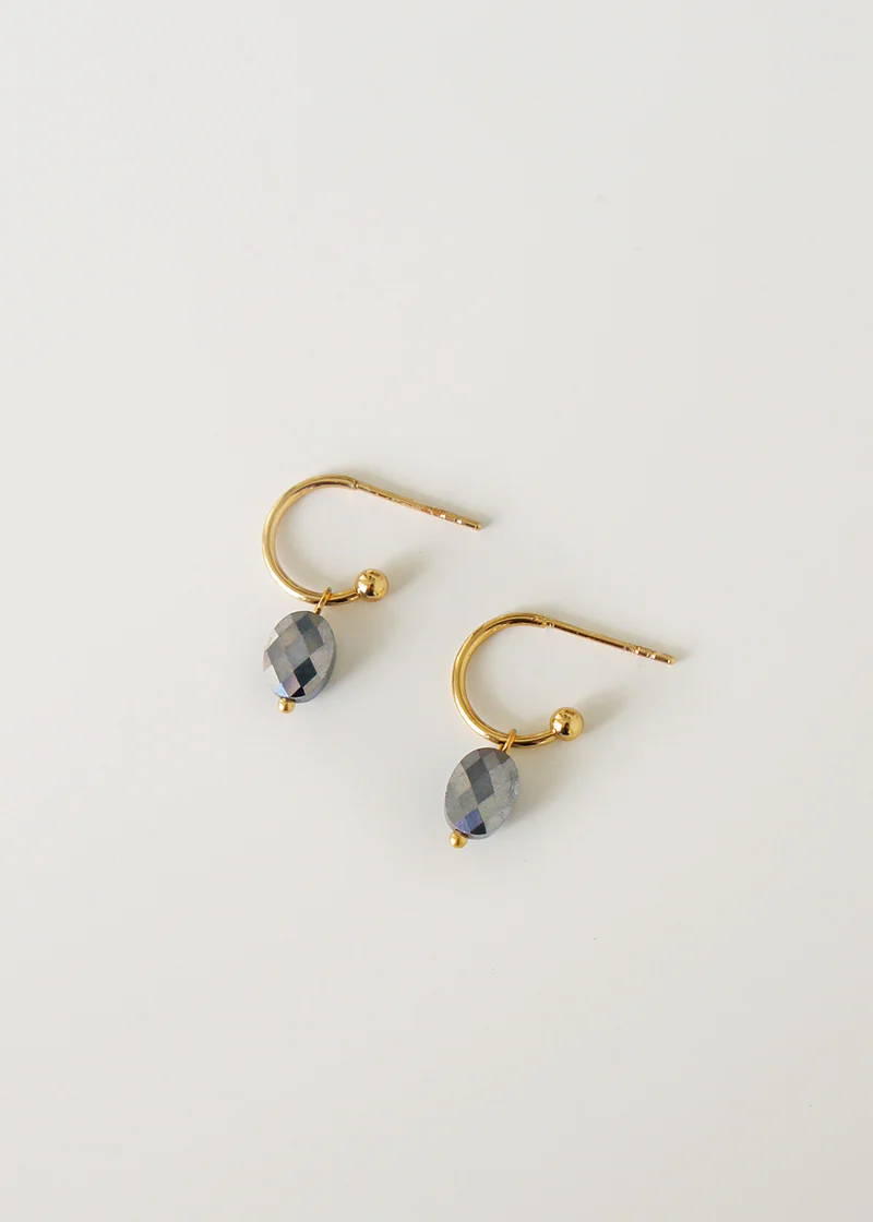 A pair of gold dangly earrings with faceted pyrite pendants