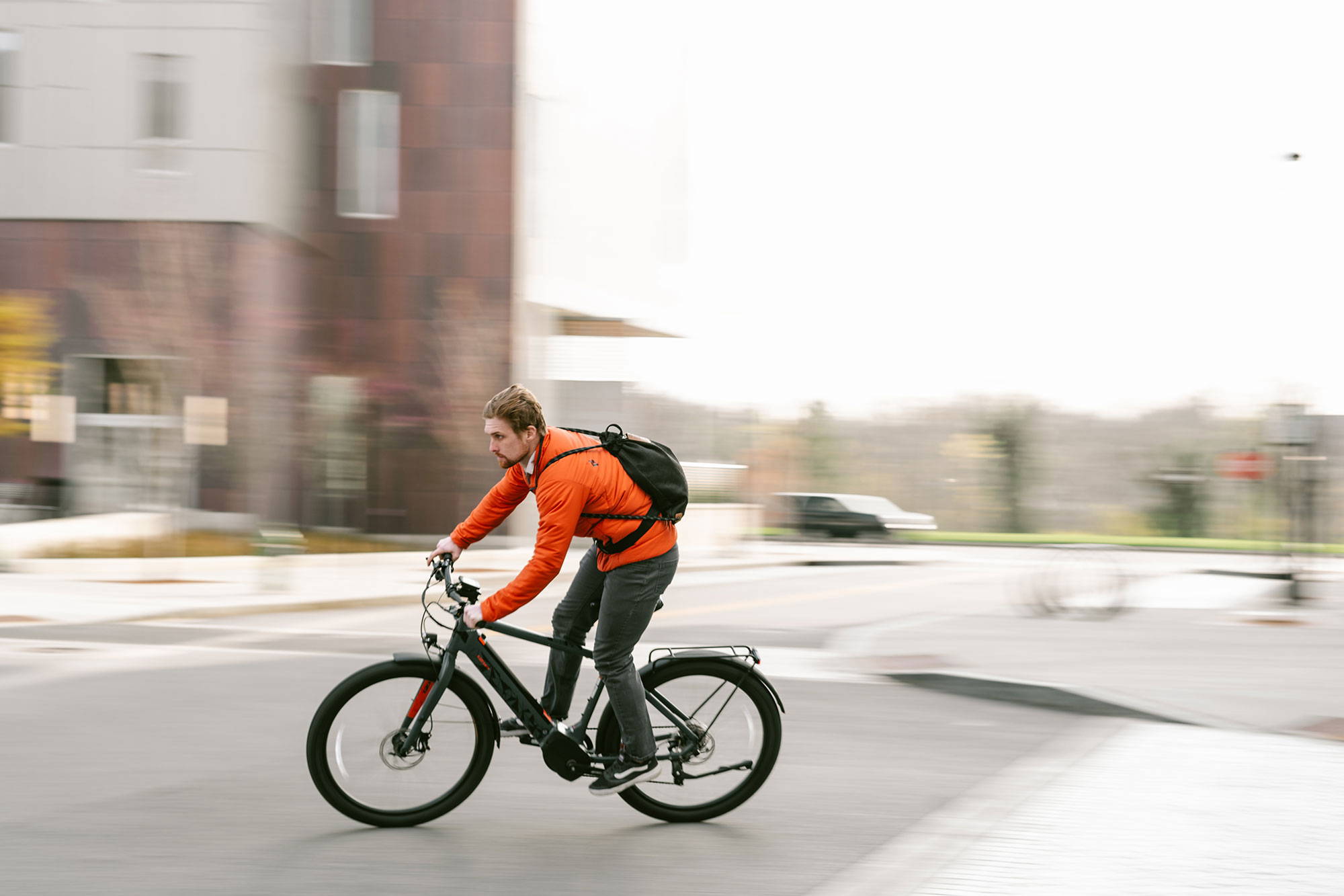 Man cycling in city with Loctote bag