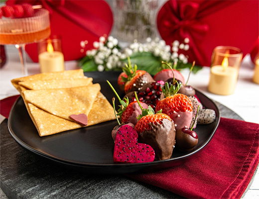 A plate with strawberries, chocolate, and crackers, decorated for a celebration.