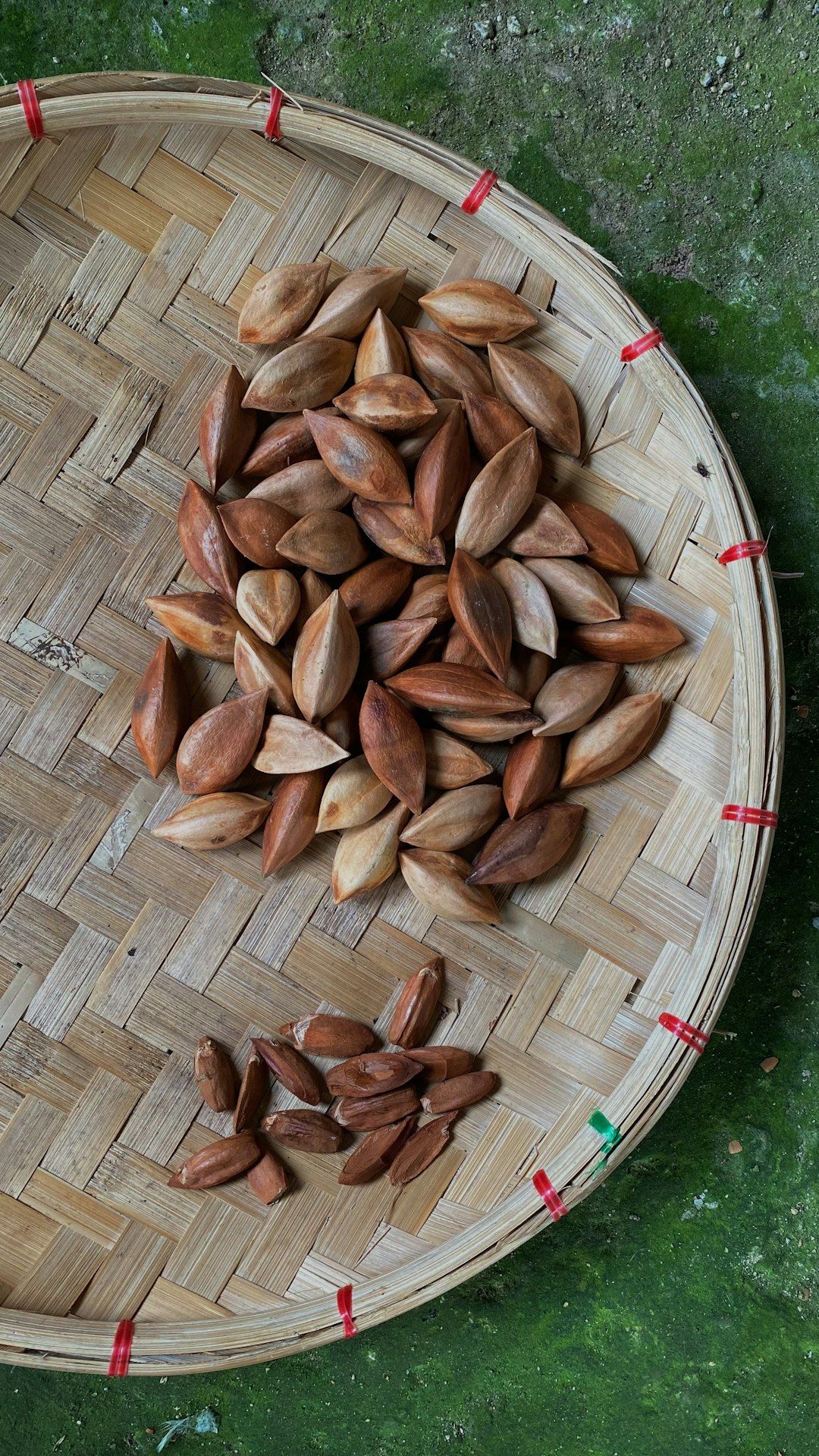 A basket of nuts on a green surface