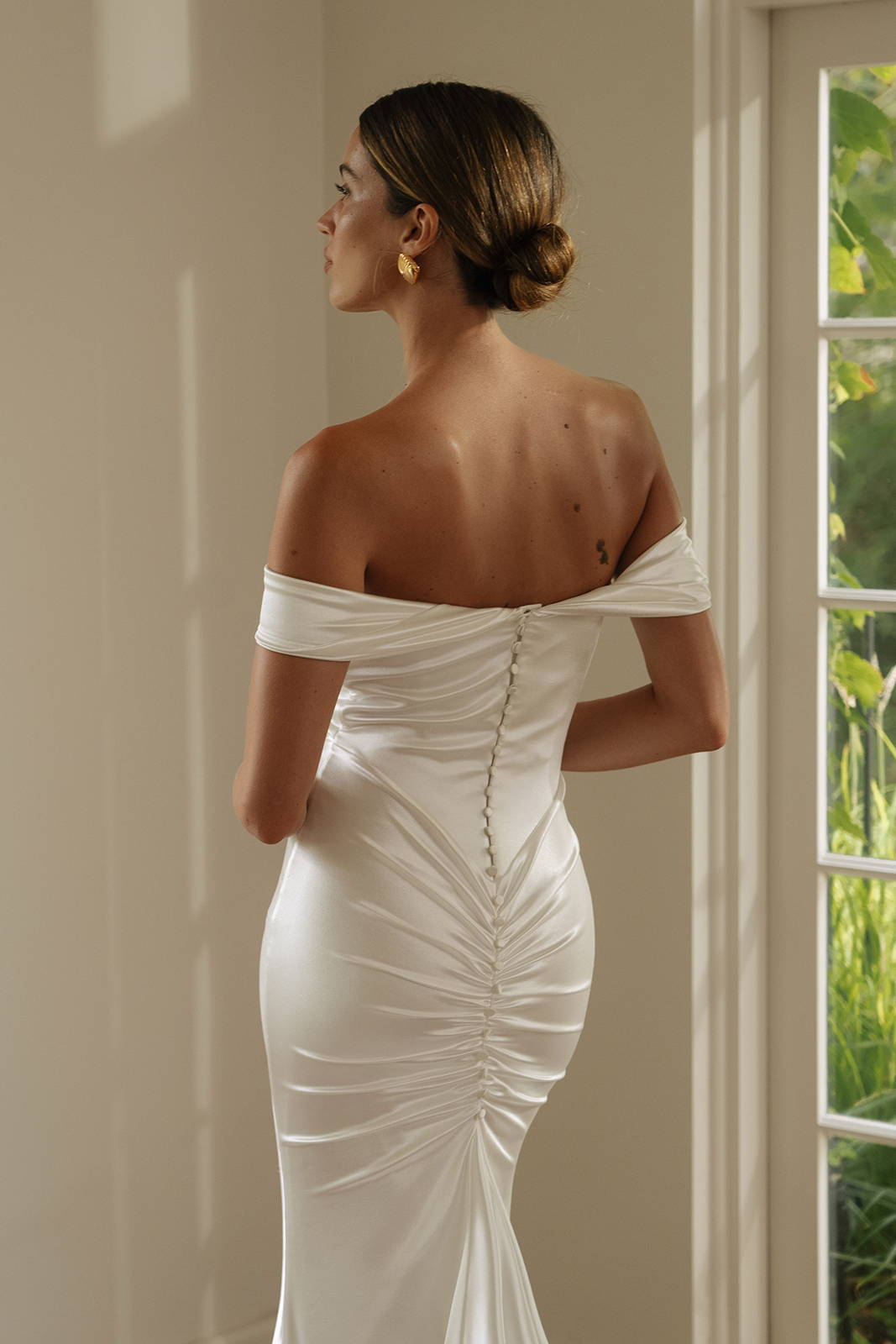The back of a woman in Cupid, an off-the-shoulder lycra bridal gown
