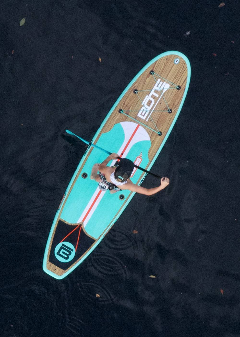 Overhead view of someone paddling the Breeze 10′6″ Classic Teak Paddle Board