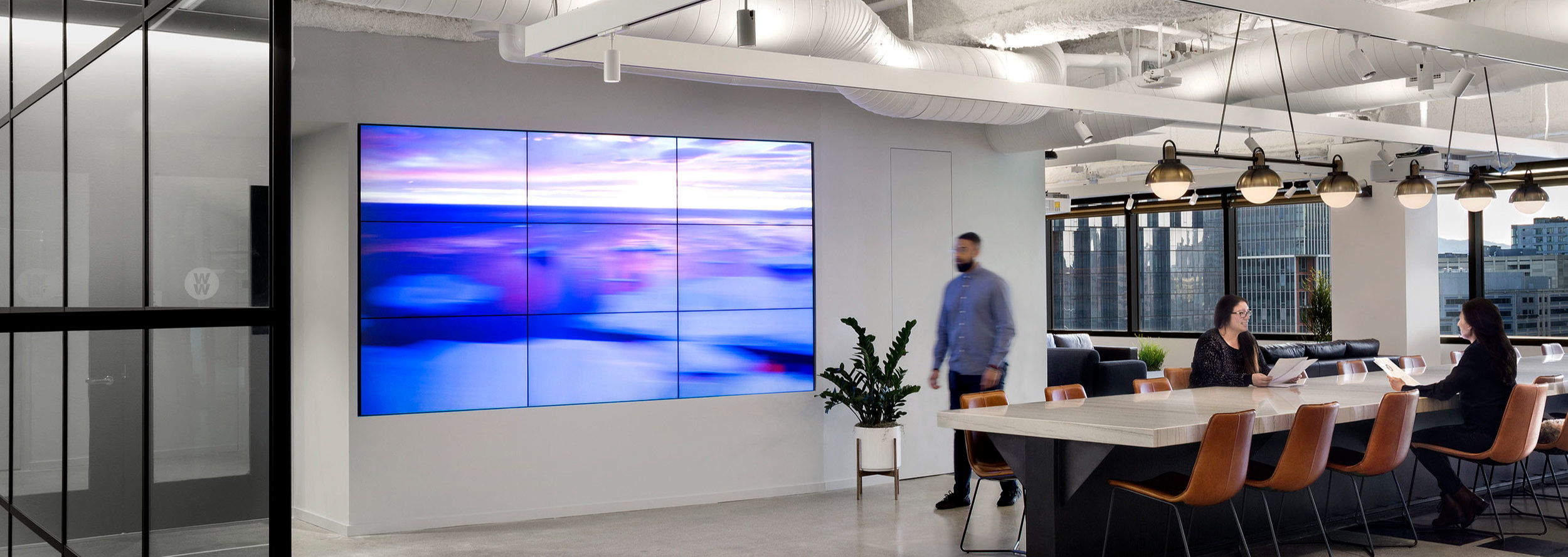 Modern office space with a large screen and meeting area.
