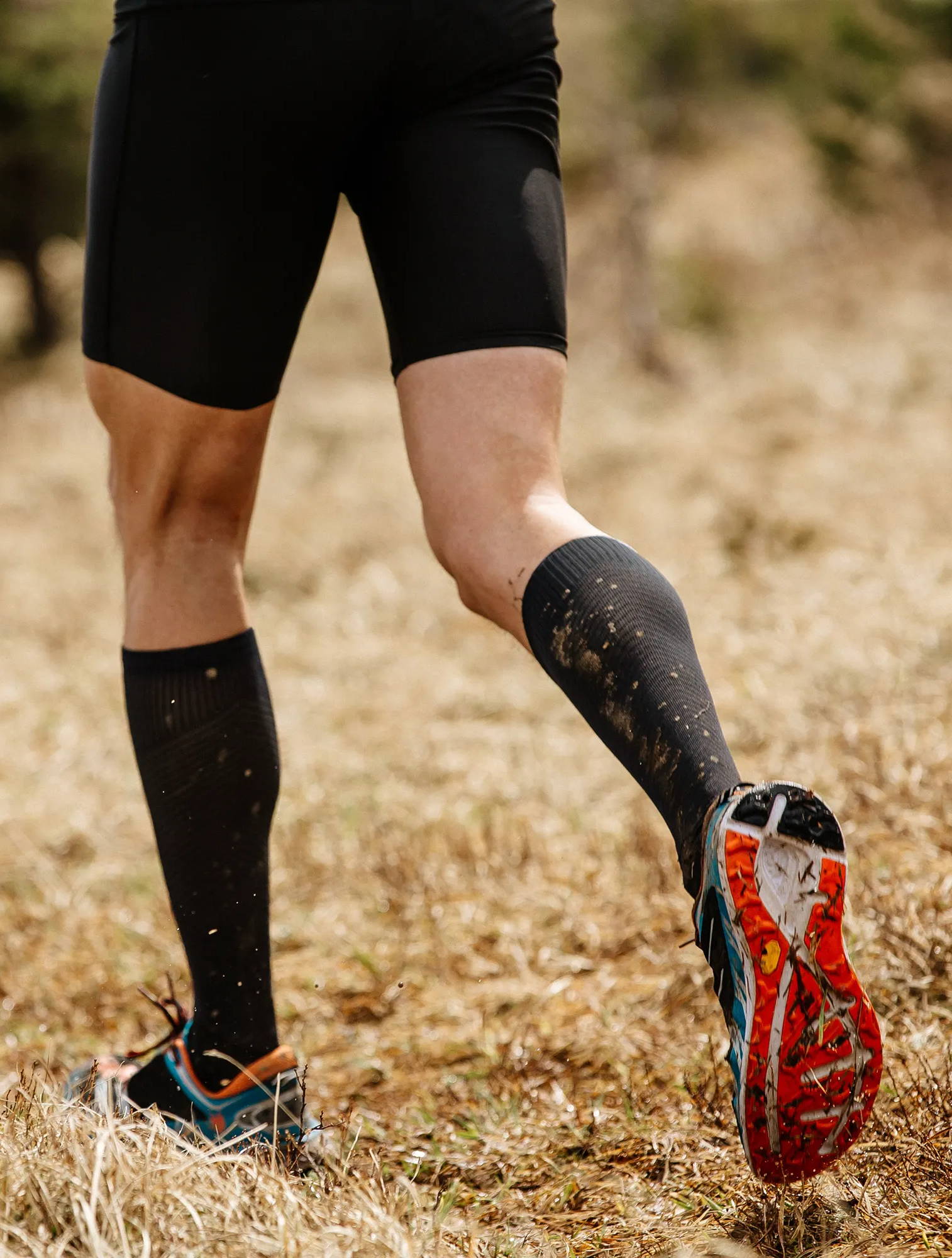 Man running in a field, man wearing compression garments while exercising