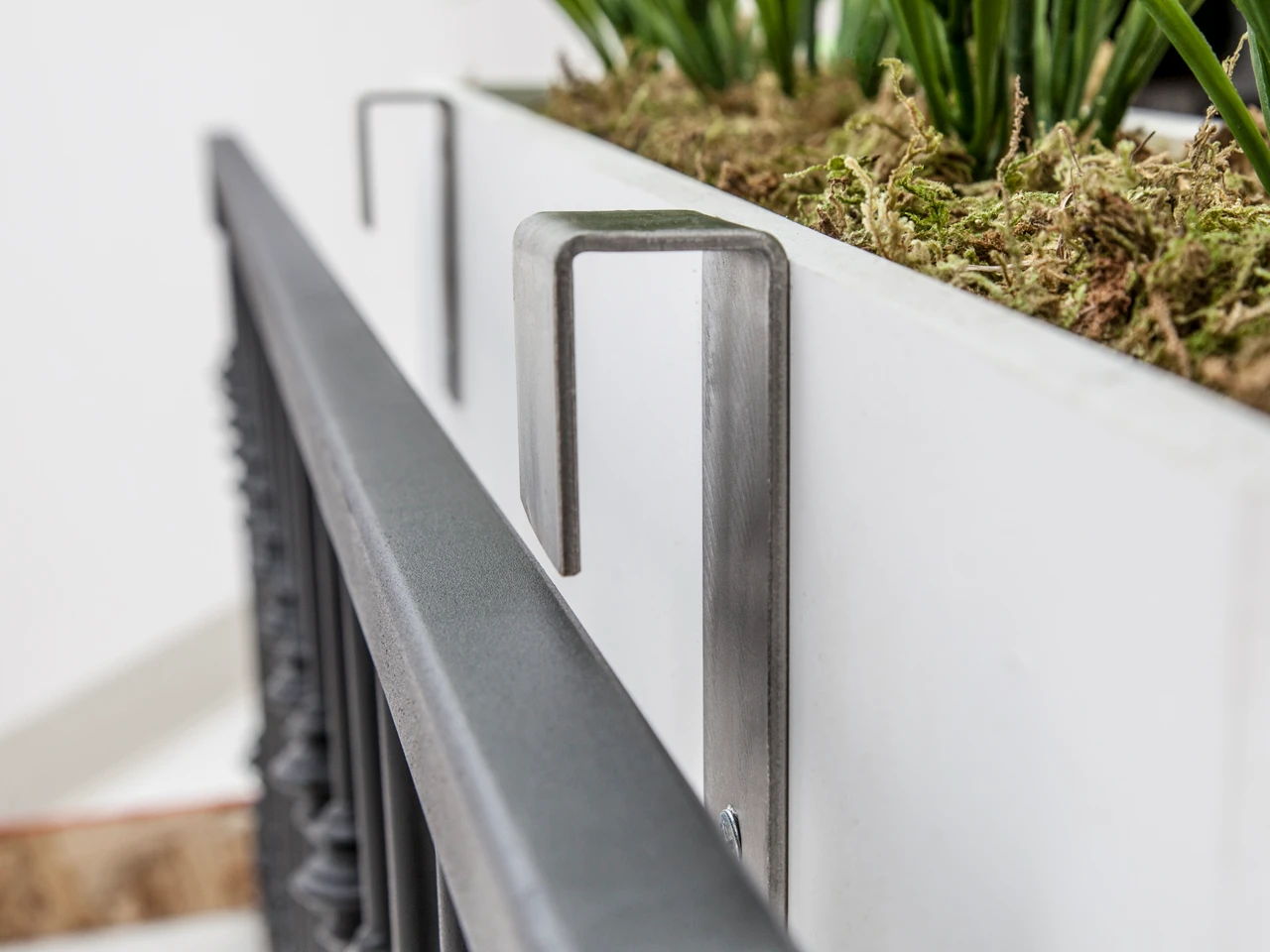 Stainless Steel Brackets attached to a window box about to be mounted to a railing