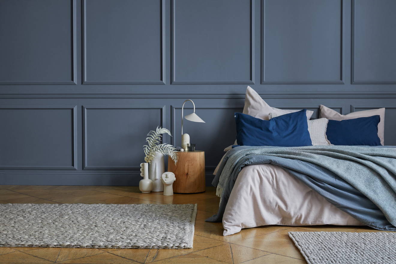 Ein Bett mit Flanell-Bettwäsche vor einer blauen Wand