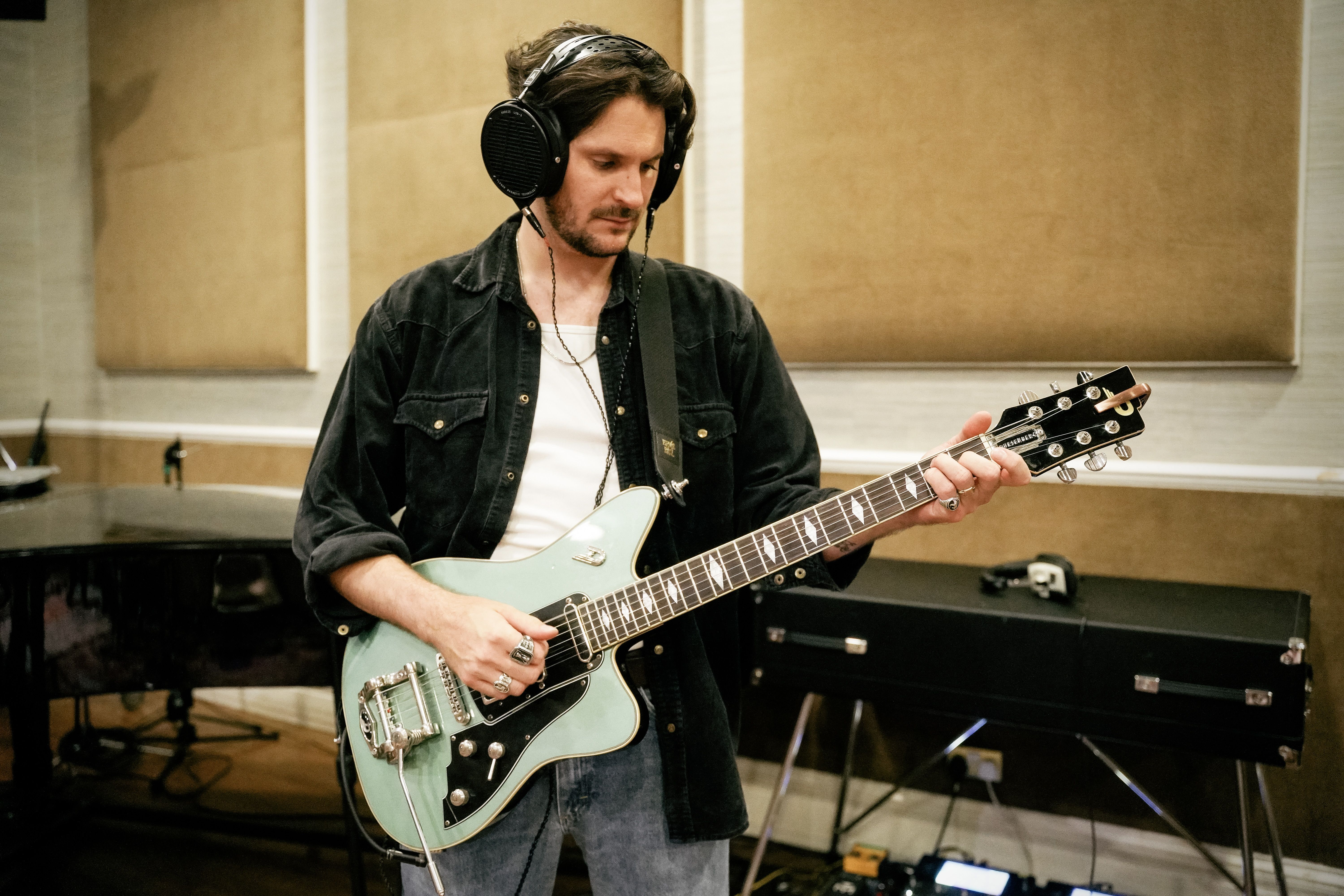 Chris Ostler playing the guitar wearing Audeze LCD-X headphones