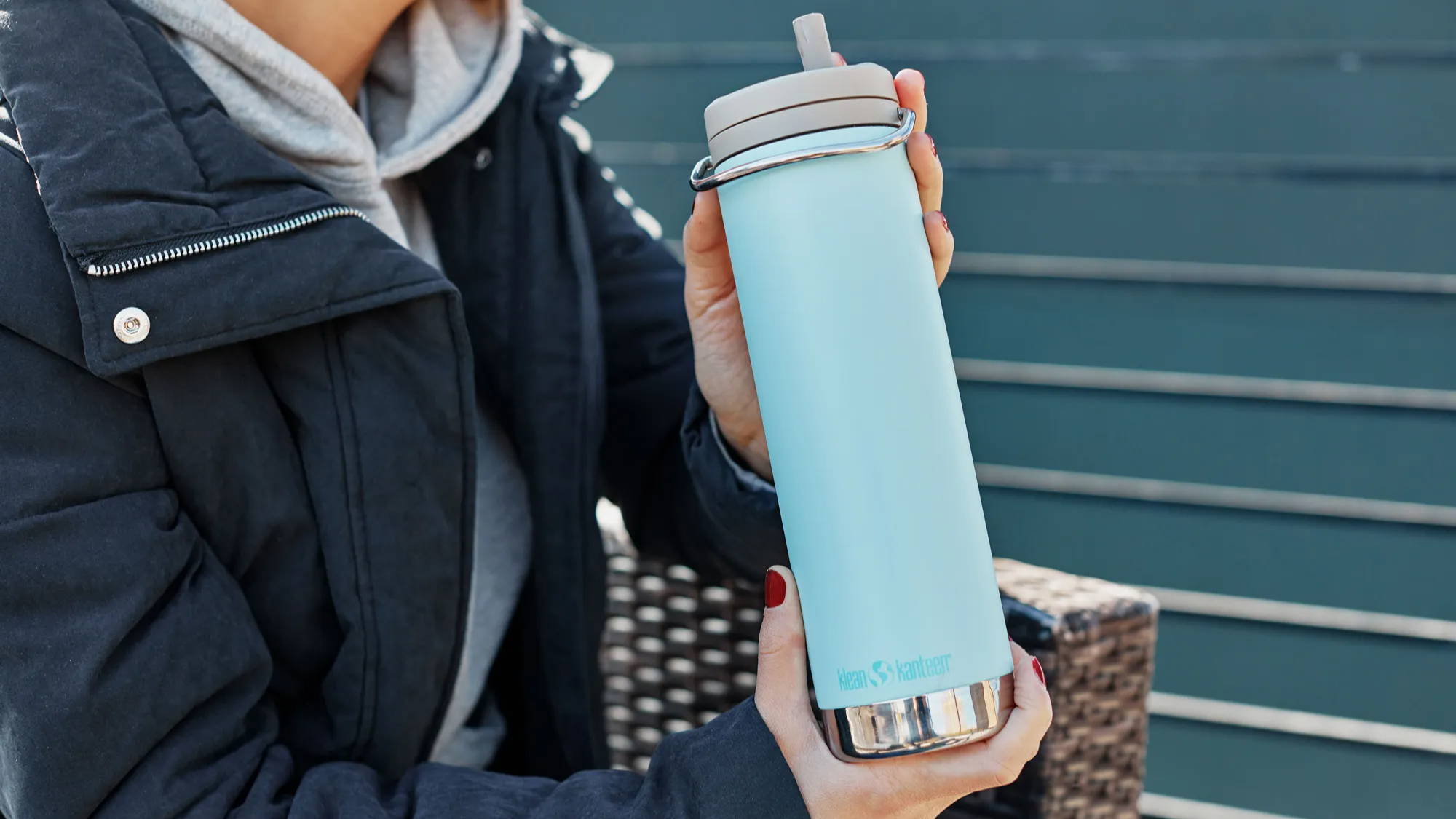 20 oz TKWide bottle with a straw cap, help by a girl in a dark blue jacket