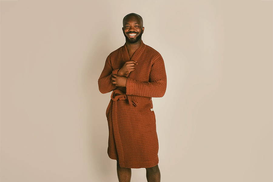 A male model wearing the organic waffle knit robe in clay