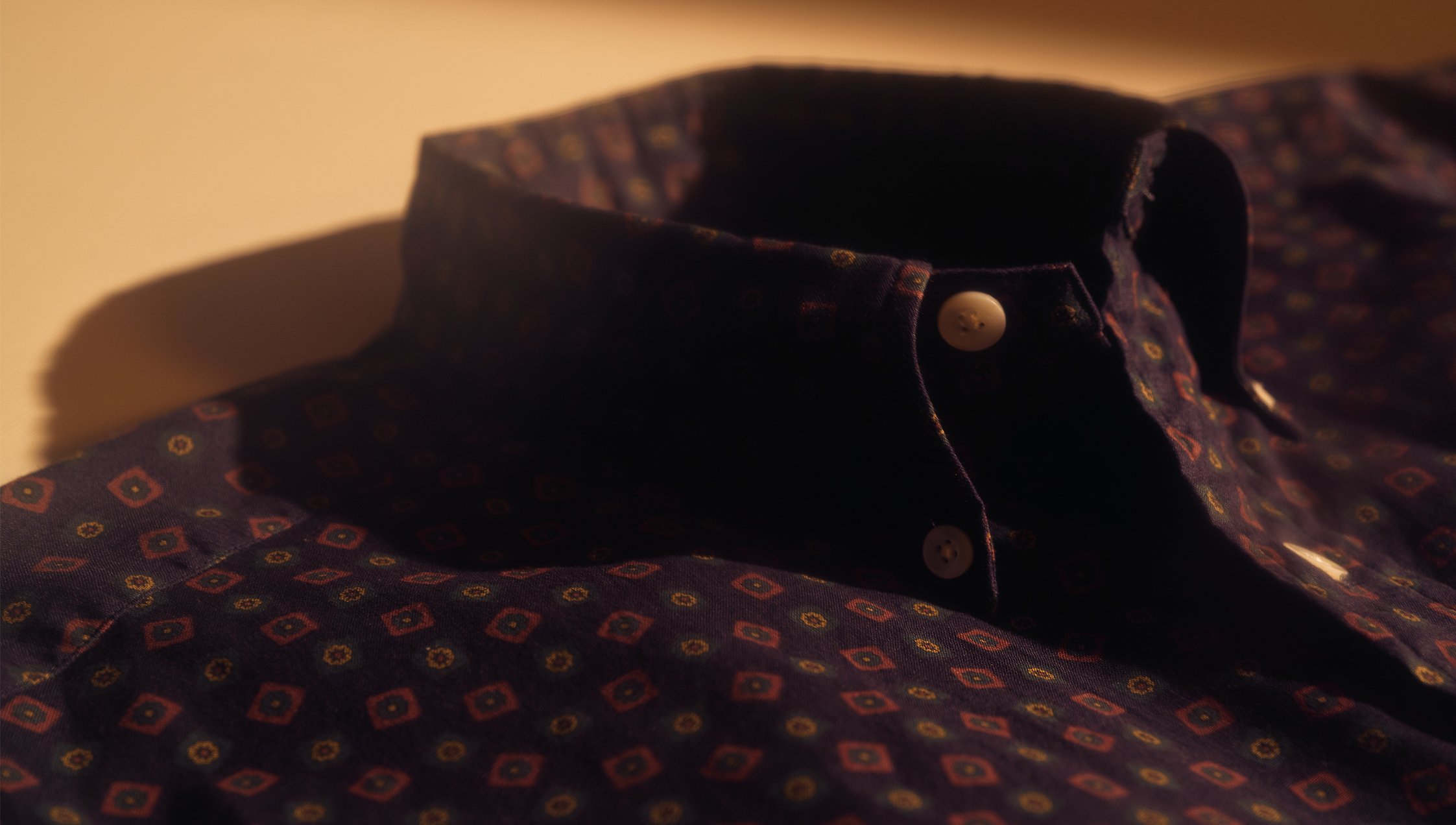 Close-up of a patterned shirt collar with buttons.
