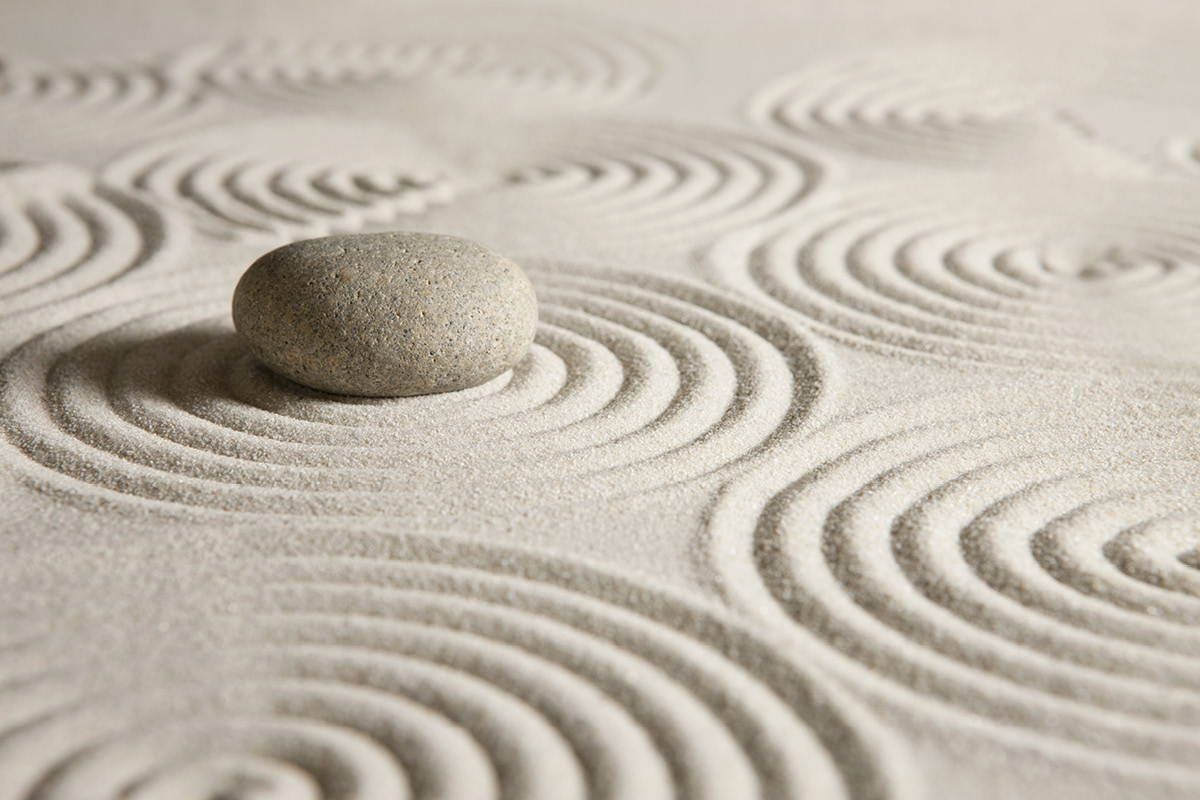 Smooth stone surrounded by sand in a zen garden