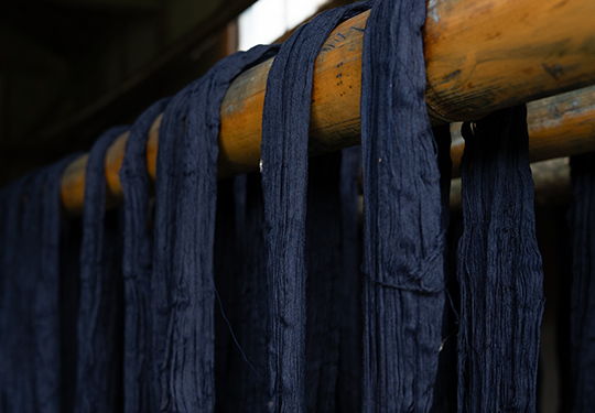 Dark blue fabric hanging on a wooden rod.