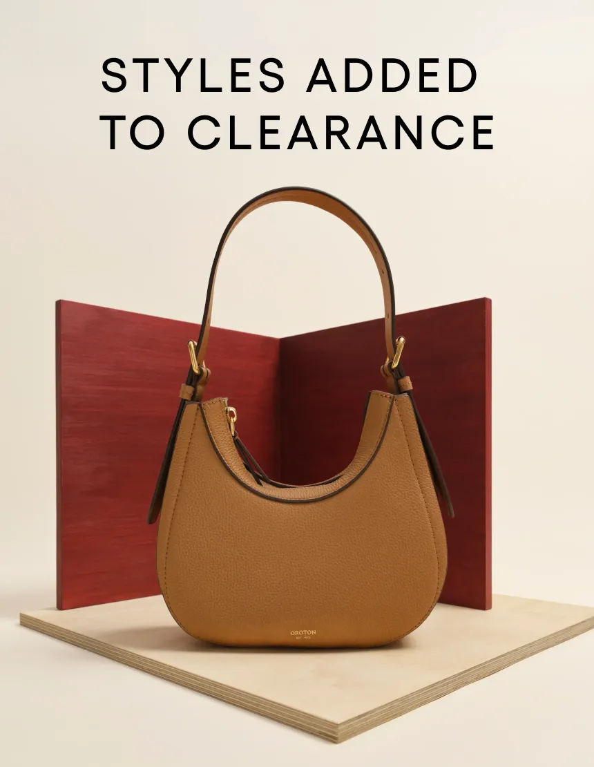 Tan handbag displayed on a pedestal with clearance sale text above.
