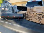 White pickup truck bed loaded with HornBlasters and Viair boxes, air tank, and wrapped mounting bracket