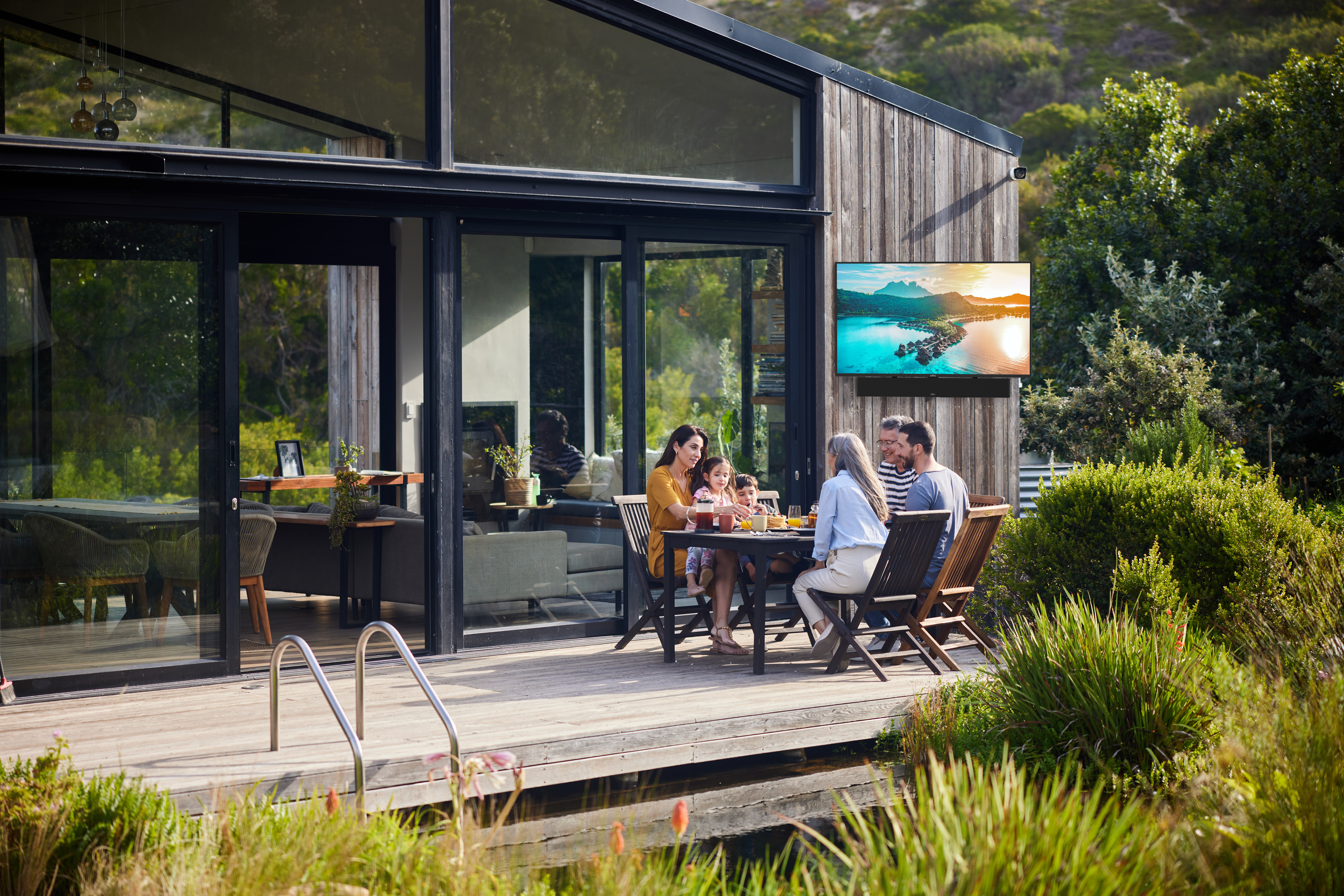 People enjoying a meal on a deck with a beautiful view.