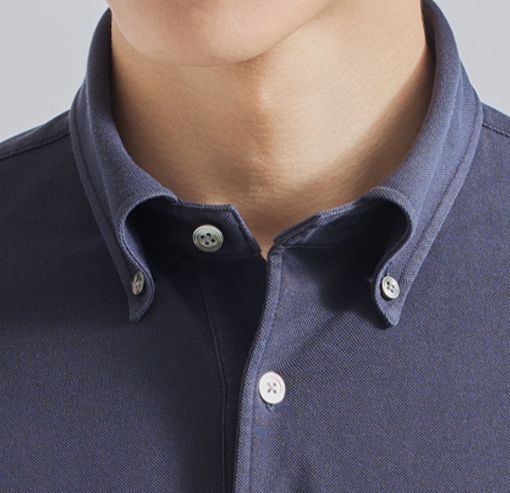 Close-up of a person’s collar on a navy blue shirt.