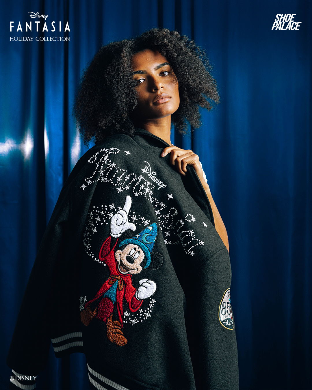 A woman wearing a black jacket with a Mickey Mouse design.
