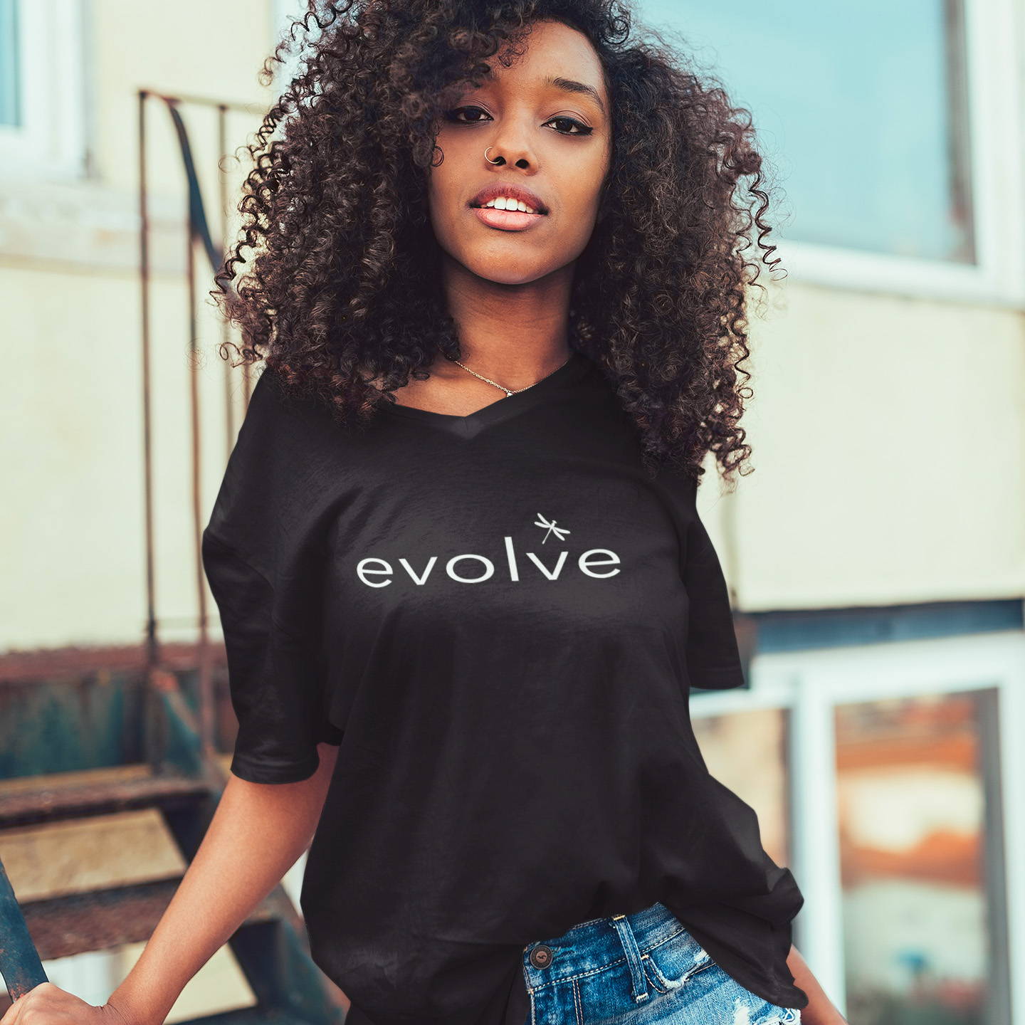 Black woman wearing a vneck shirt that says evolve