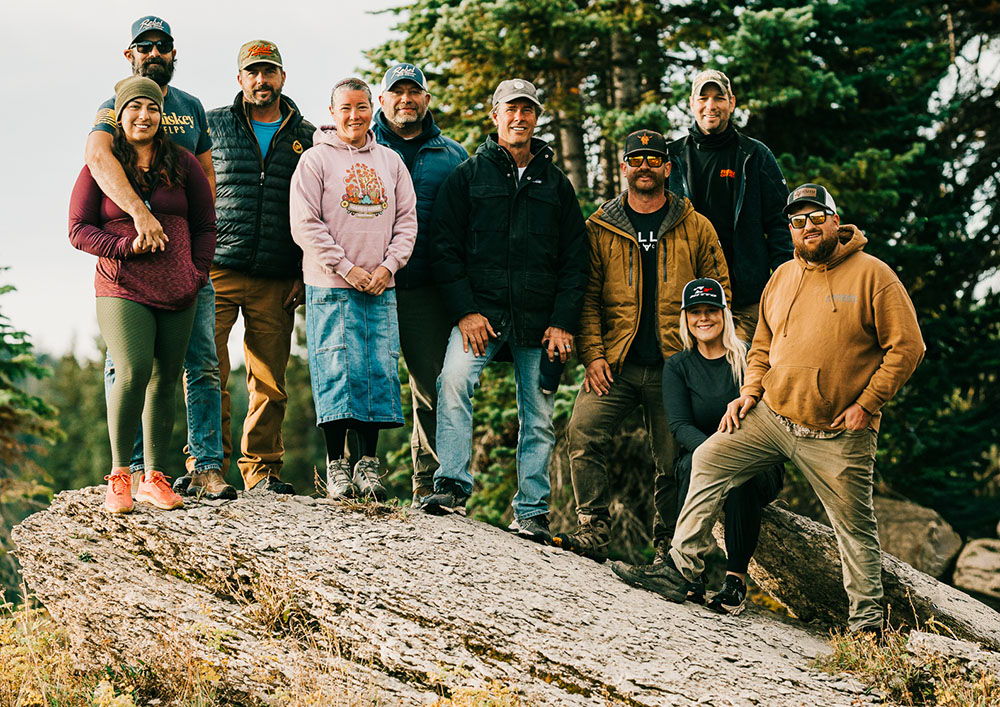 Group of people posing on a rock in nature.