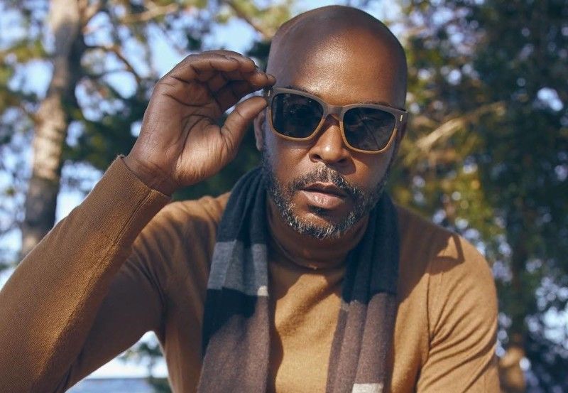 Stylish bald man wearing Oxford, squared wooden sunglasses