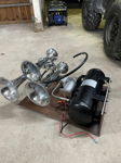 Chrome Outlaw 228H train horn bells with air tank and compressor on garage floor thumbnail