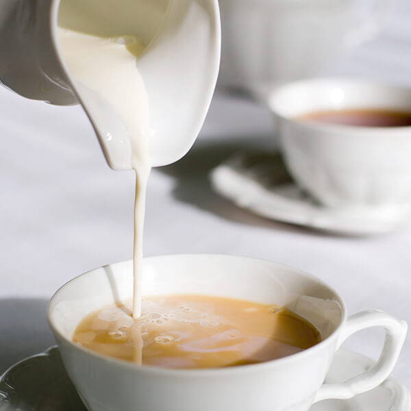 High Quality Organics Express milk pouring into tea 